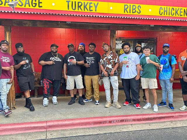 CHH Austin group photo in front of a red wall